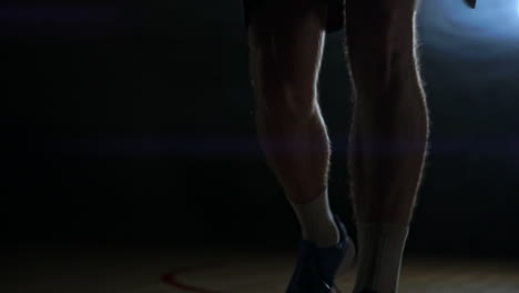Dribbling-basketball-player-close-up-in-dark-room-in-smoke-close-up-in-slow-motion